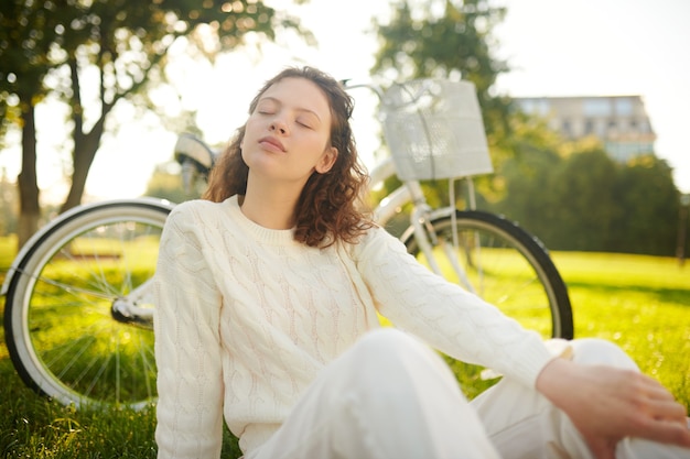 A girl sitting with her eyes closed and looking relaxed