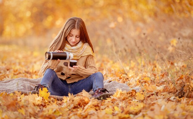 Girl sitting in yellow leaves