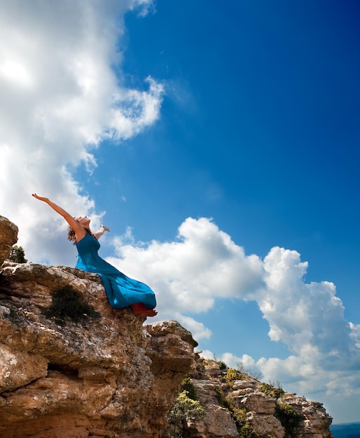 Girl and sky concept. Girl with open arms to the blue sky