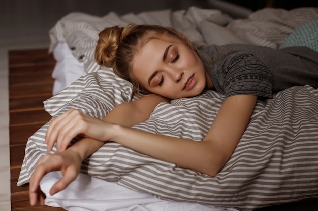 girl sleeps in the bed at home. blurred space. large portrait