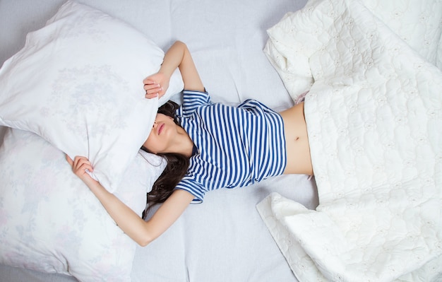 Girl sleeps in a white bed at home