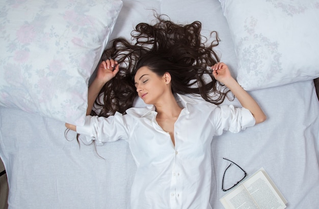 Girl sleeps in a white bed at home