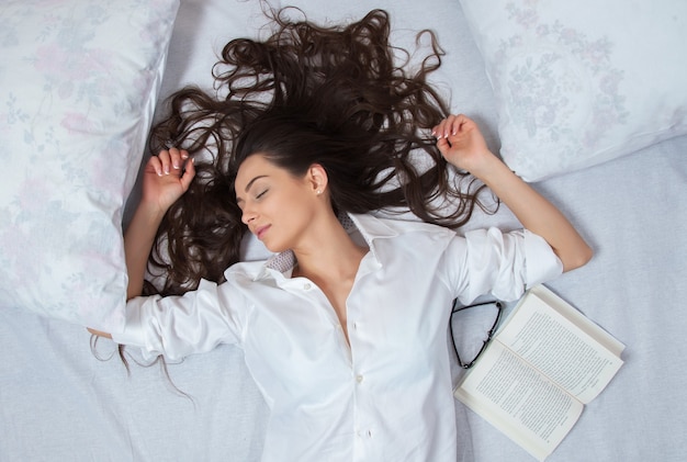 Girl sleeps in a white bed at home