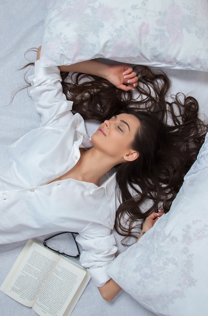 Girl sleeps in a white bed at home