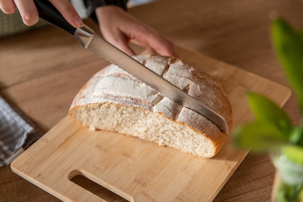 девушка нарезает хлеб, домашняя еда, кухонный фон