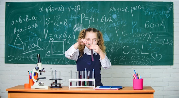 Girl smart student conduct school experiment School pupil study chemical liquids School chemistry lesson Test tubes with substances Formal education Future microbiologist School laboratory