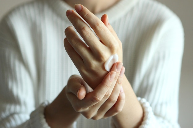 Girl smears her hands cosmetic cream skin care