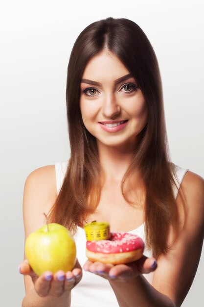 Girl smiles while holding an apple in her arms