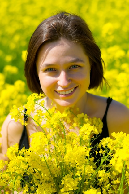 a girl smiles in a yellow field in summer