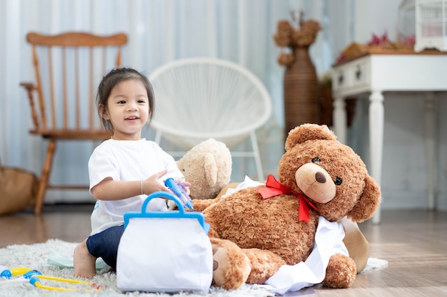 girl smiling and lying on the floor with playing teddy bear