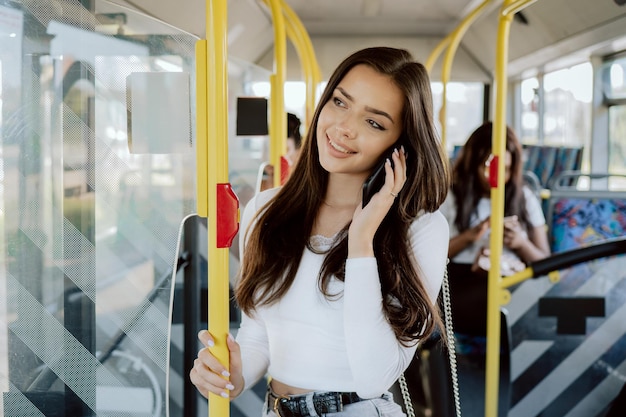 La ragazza trascorre la mattina sull'autobus per andare all'università la donna usa i colloqui sui trasporti pubblici al telefono