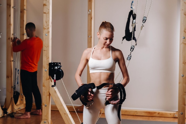 A girl in a sports uniform put devices on her hands for
mounting on a simulator where she will do body stretching