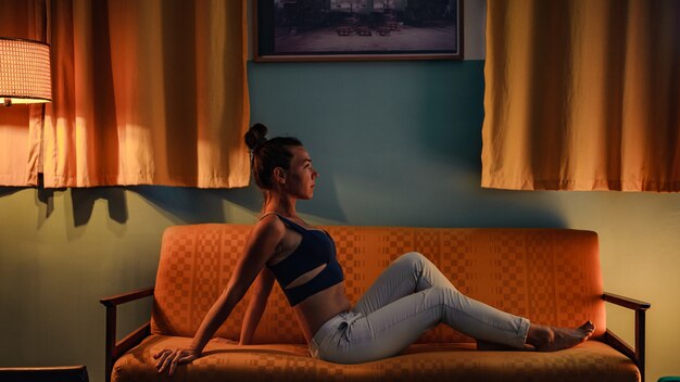 Girl in sportswear posing on a comfortable couch