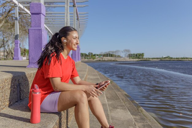 Girl in sportswear sitting on stairs taking a break