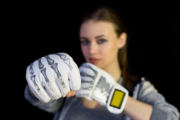 Girl sportswoman in gloves for boxing on black.