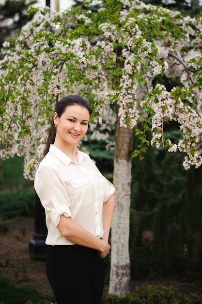 Girl in the spring park near a flowering tree.