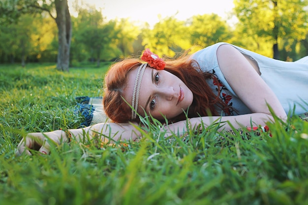 Girl in the spring walks through the apple alley in the evening sunset