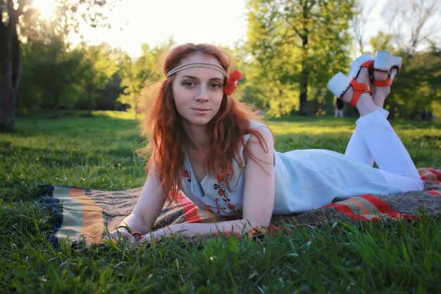 Girl in the spring walks through the apple alley in the evening sunset