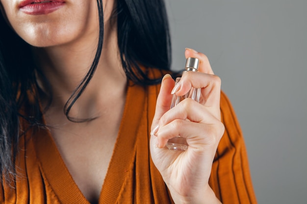 Girl sprinkles perfume on herself