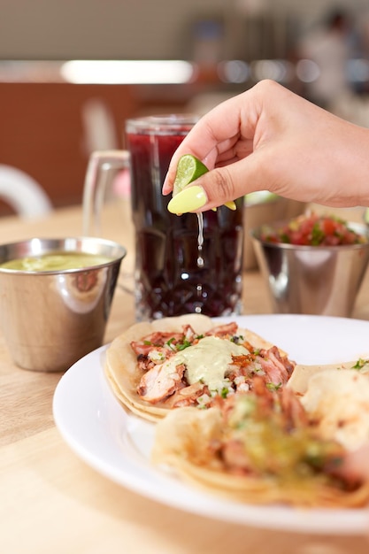 Foto ragazza che spreme il limone nei suoi deliziosi tacos