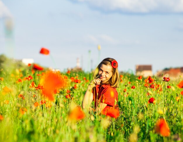 Girl stand with arms outstretched in the poppies field and enjoy the nature