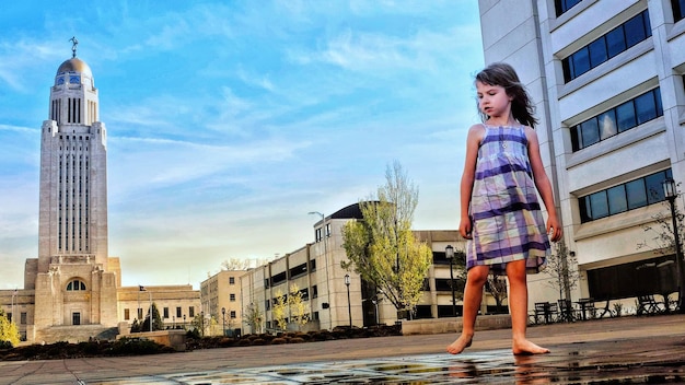 Girl standing against nebraska state capitol building