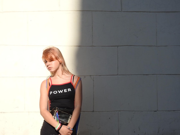 Photo girl standing against wall