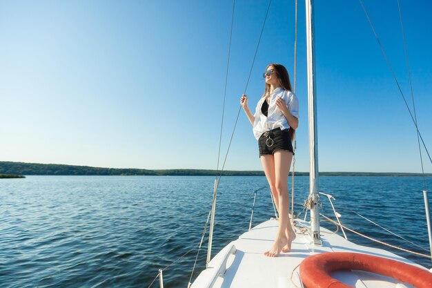 Girl standing on the bow of a sailboat boat Copy space