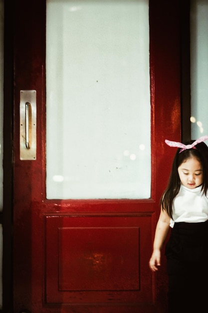 Girl standing by closed door