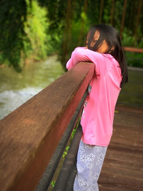 Photo girl standing by railing on footpath outdoors