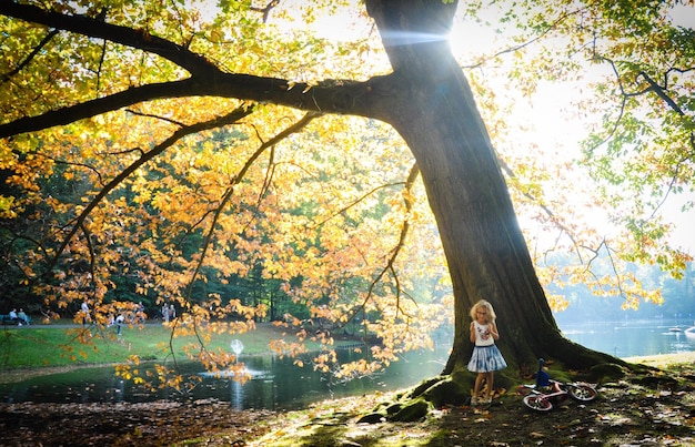 Photo girl standing by tree at lake