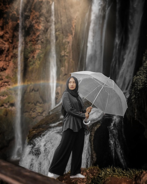 Photo girl standing by waterfall in forest