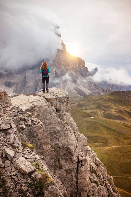 Photo girl standing at the edge of rock. dolomites, italy.