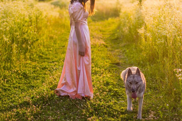 Girl standing in the field in a pink dress