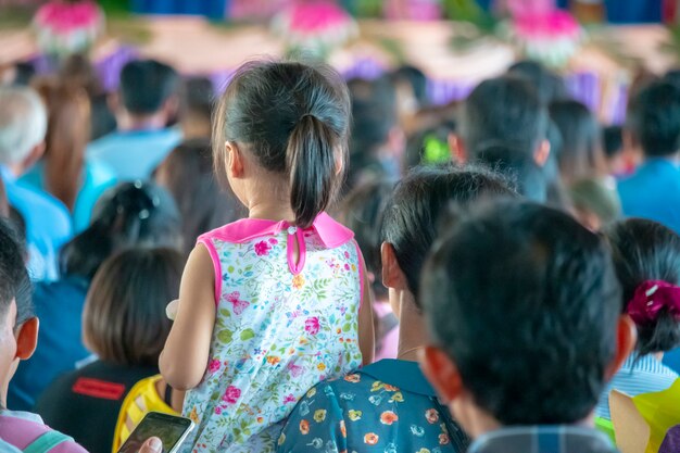 立っている女の子、ホールの人々のグループ