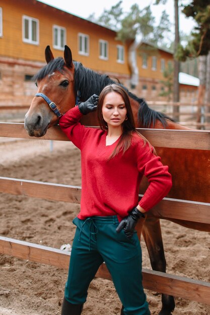 A girl standing next to a horse