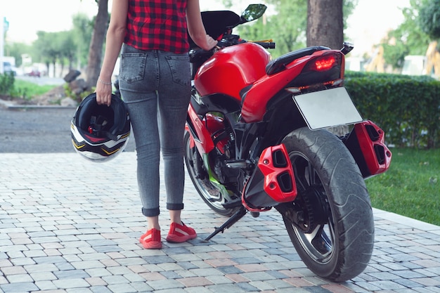 A girl standing next to a motorcycle