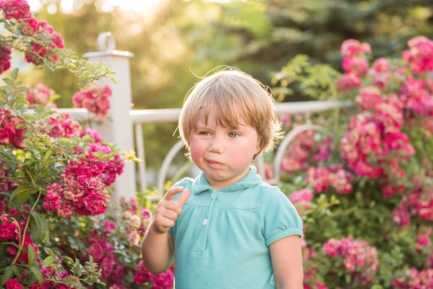 Ragazza che sta vicino ai cespugli di rose. il concetto di allergia