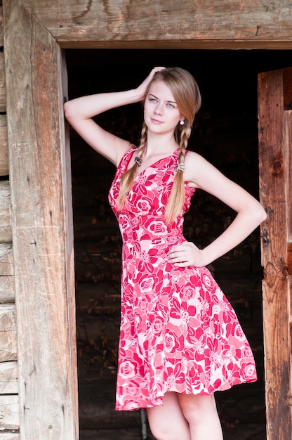 Photo girl standing in an old wooden house doors