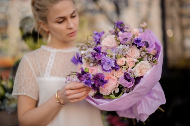 驚くべき花の花束と屋外に立っている女の子