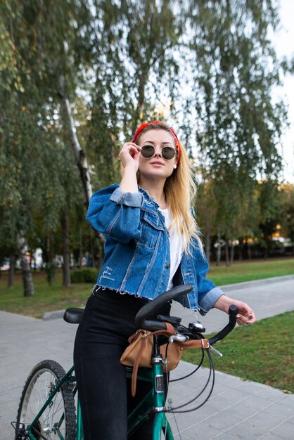 girl standing on ride in a bike park and fixing glasses