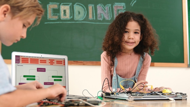 Foto ragazza in piedi mentre ripara la scheda elettronica utilizzando la pedagogia del cacciavite