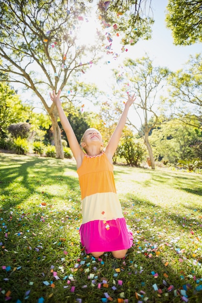 Girl standing with arms outstretched in park