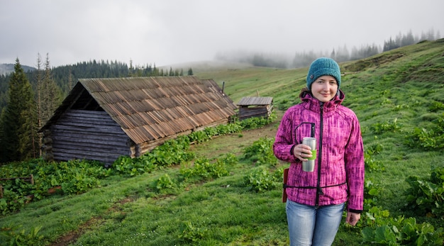 Photo girl standing with a cup in the morning in the mountains