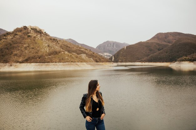 Girl stands on a hill.