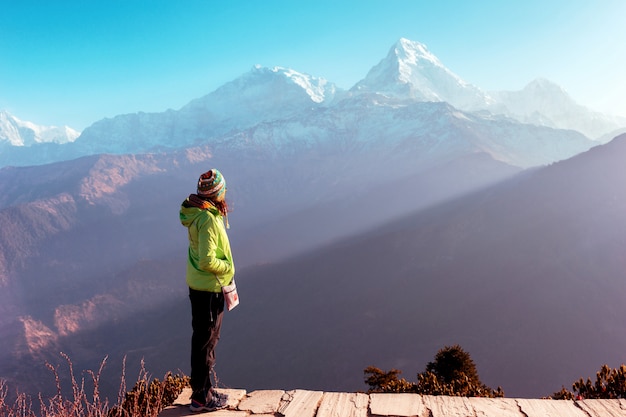 Фото Девочка стоит на фоне заснеженных гор, гималаев, непал