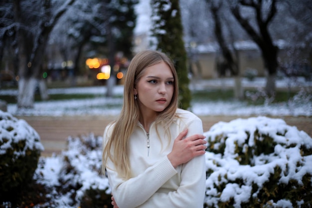 a girl stands in the snow in front of a fire place