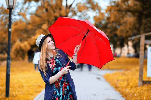 Girl in the street with an umbrella for a walk on an autumn day