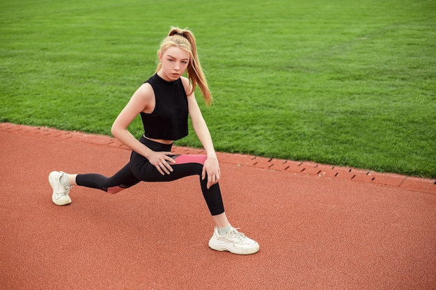 Girl stretches at the stadium