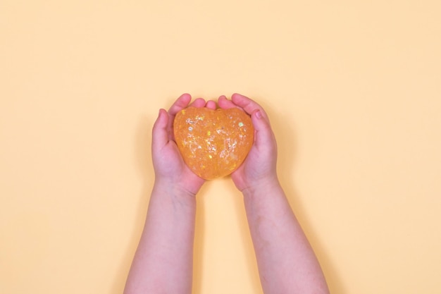 Girl stretching colorful orange slime on the sides Children's hands playing slime toy on an orange background